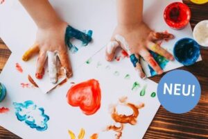 Kinderhände malen mit Fingerfarben auf Papier, bunte Formen wie Herz, Sonne und Wolken sind zu sehen.
